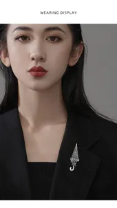 Close-up view of an elegant crystal umbrella brooch pinned on a black blazer lapel