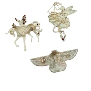Rückansicht von Vintage-Broschen in Mattgold mit Feen- und ägyptischen Vogelmotiven