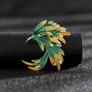 Detailed macro view of an elegant vintage wing brooch with green enamel and white crystals