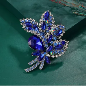 Vintage luxury leaf-shaped brooch with deep blue crystals and silver-tone finish