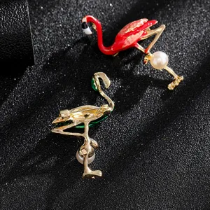 Macro view of vintage flamingo brooches with enamel finish and elegant pearl accents.