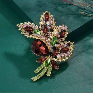 Detailed macro shot of a luxurious vintage leaf-shaped brooch with colorful crystals.