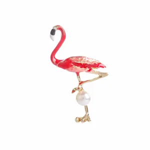 Detailed close-up of an elegant flamingo brooch with pink enamel and a pearl accent.
