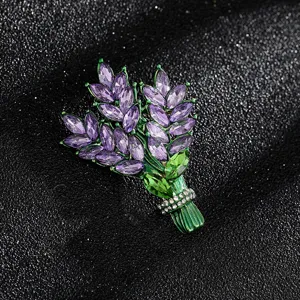 Close-up of elegant floral brooch with purple and green crystals on black background