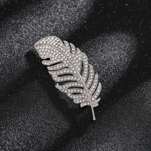 Detailed macro view of a silver feather brooch adorned with sparkling rhinestone crystals
