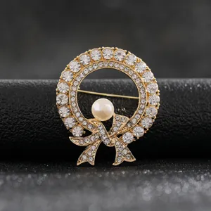 Close-up detail of a vintage elegant gold wreath brooch featuring crystal bow and pearl