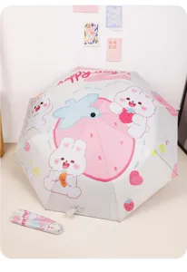Vue détaillée du motif lapin fraise mignon sur le parapluie pliant rose et blanc