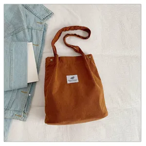 Detalle del bolso tote de pana marrón con parche de hoja vintage y remaches de metal