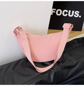 Bolso bandolera minimalista de nailon rosa en forma de media luna con correa ancha