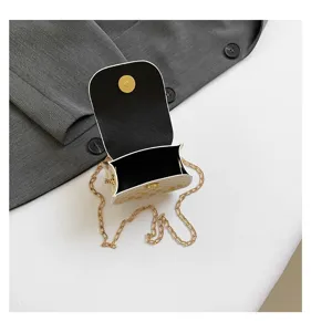 Vista interior detallada del mini bolso de cadena crema con cierre magnético dorado