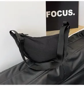 Vista lateral de un bolso de nailon negro con correa ajustable para mujer