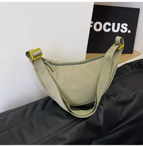 Bolso bandolera de nailon verde claro en forma de media luna con hebillas amarillas