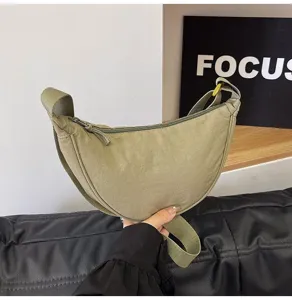 Vista detallada de un bolso bandolera de nailon verde con textura de tela dura