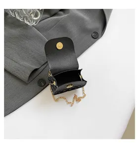 Vista detallada del mini bolso bandolera negro con cadena dorata y cierre magnético.
