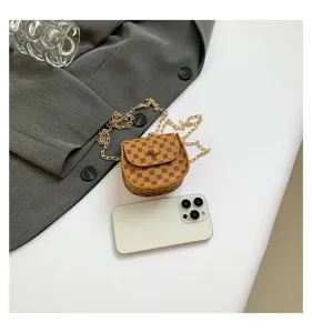Minibolso bandolera vintage con cadena dorada, junto a un smartphone para comparar