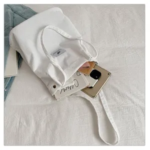 Vista detallada de bolsa tote de pana blanca con gran capacidad y tableta adentro