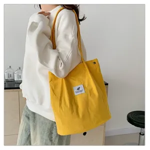 Bolso tote minimalista de pana amarilla de gran capacidad para mujer en uso diario