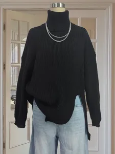 Details of black high turtleneck knitted sweater with side slits and long sleeves for women.