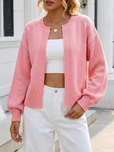 Primo piano del dettaglio del cardigan in maglia rosa con texture morbida e maniche.