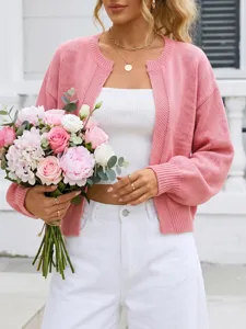 Vista dettagliata del cardigan in maglia rosa elegante che mostra la sua consistenza morbida.