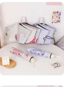 Détail rapproché de parapluies pliants mignons avec motifs de lapin et de dinosaure