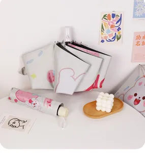 Vue détaillée du parapluie pliable lapin fraise avec sa housse de rangement assortie.