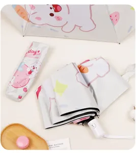 Gros plan d'un parapluie de dessin animé lapin rose et blanc plié avec sa pochette.