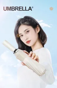 Asiatisches Model hält einen kompakten beige Automatik-Regenschirm vor blauem Himmel.