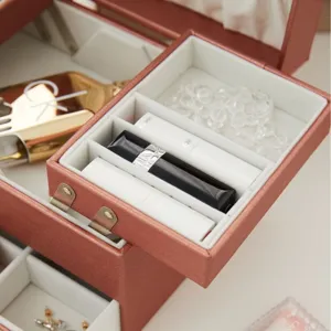 Elegante joyero de tres capas en PU oro rosa con gran capacidad para guardar accesorios.
