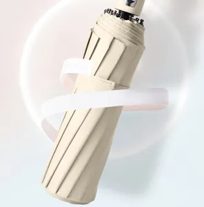 Parapluie pliante beige compact pour protection solaire et pluie avec poignée automatique.