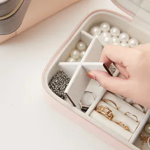 Portable travel jewelry box with adjustable dividers and soft velvet lining for rings.