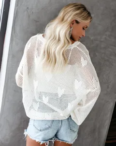 Dames losse opengewerkte gebreide doorschijnende truien met hartjespatroon en jeansshorts.