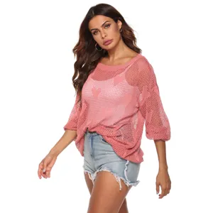 Gedetailleerd overzicht van roze opengewerkte trui met hartje binnenlaag en denim shorts.