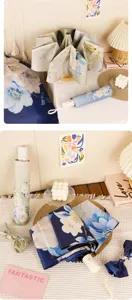 Detailed view of folding floral sun umbrella, elegant peony print, compact portable design.