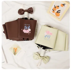 Detailed view of tulip print automatic umbrellas with bow tie handle decoration