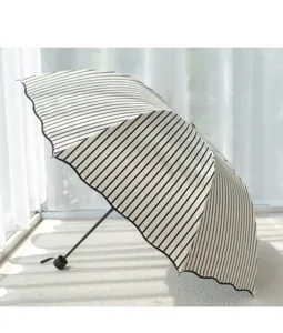 Black and white striped folding sun umbrella for women uv protection rain and shine use.