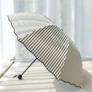 Black and white striped folding umbrella for sun and rain protection, portable compact design.