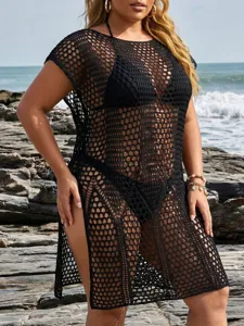 Detailed view of a black plus size crochet beach cover-up dress on a rocky shore