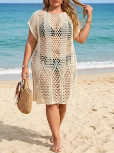 Full view of plus size beige crochet beach cover up dress on model at a sunny beach