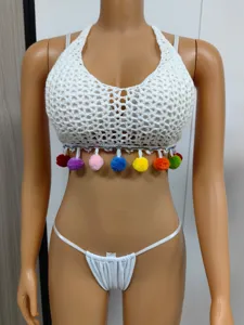 Crochet halter bikini top with colorful pom pom fringe and matching string bottom for beach.