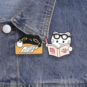 Macro view of cute cartoon black and white cat enamel pins pinned on denim jacket fabric