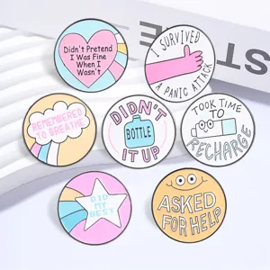 Close-up of seven macaron-colored mental health enamel pins with healing quotes