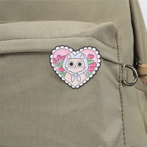 Gros plan d'un pin's en émail chat en forme de cœur sur un sac à dos kaki robuste