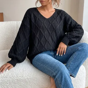 Black V-neck cable knit sweater detail showing textured fabric and relaxed fit style.