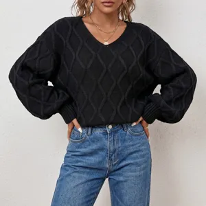 Detailed view of women's black V-neck cable knit sweater showcasing fine texture and design.