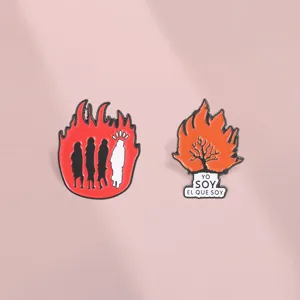 Vue détaillée des pin's émaillés arbre de feu et silhouettes religieuses pour sacs