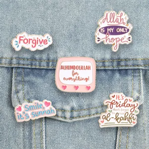 Detailed view of Islamic metal enamel pins with faith-based English quotes on denim