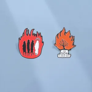 Vue détaillée de broches émaillées religieuses avec flamme et buisson ardent en ombre.