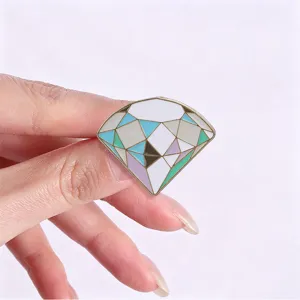 Close-up detail of a macaron-colored diamond geometric faceted enamel pin accessory