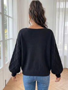 Back view detail of women black knit sweater with cable sleeve texture and cozy casual loose fit.